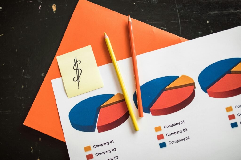 A creative arrangement of financial pie charts with colorful pencils and a dollar note, perfect for business themes.